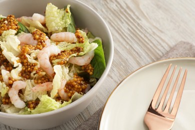 Photo of Delicious salad with Chinese cabbage, shrimps and mustard seed dressing served on white wooden table, closeup
