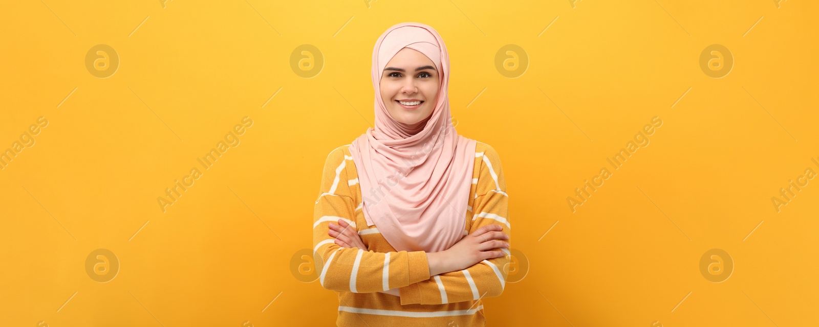 Image of Portrait of Muslim woman in hijab on yellow background. Banner design