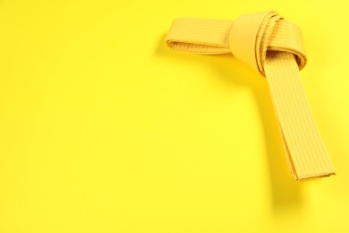 Photo of Karate belt on yellow background, space for text