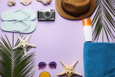 Frame of different beach objects on violet background, flat lay. Space for text
