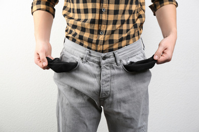Photo of Man showing empty pockets on light background, closeup
