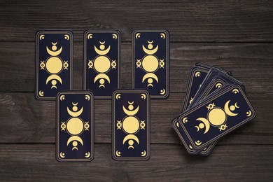 Tarot cards on black wooden table, flat lay. Reverse side