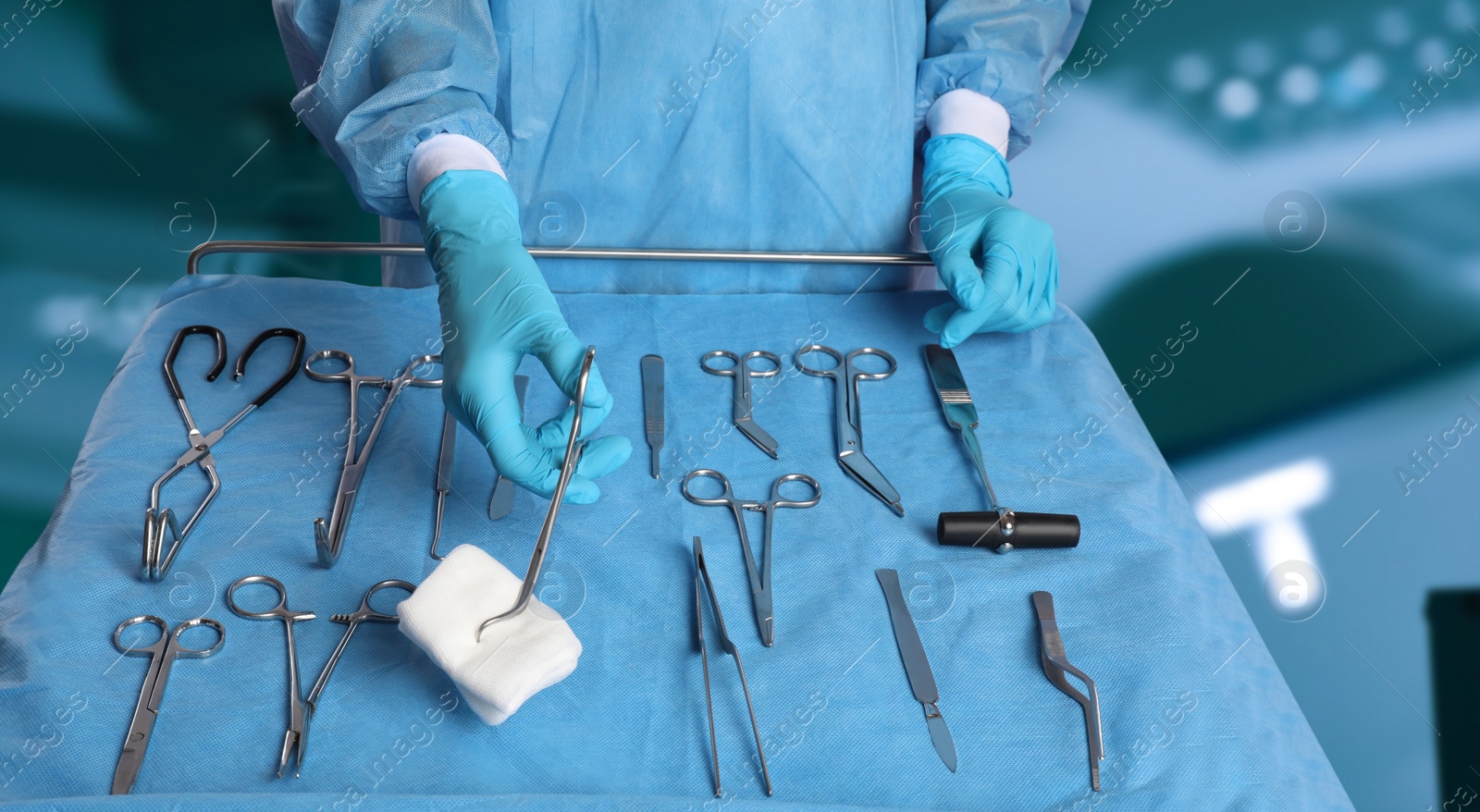 Image of Nurse near table with different surgical instruments in operating room, closeup