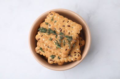 Photo of Cereal crackers with flax, sesame seeds and thyme in bowl on white marble table, top view