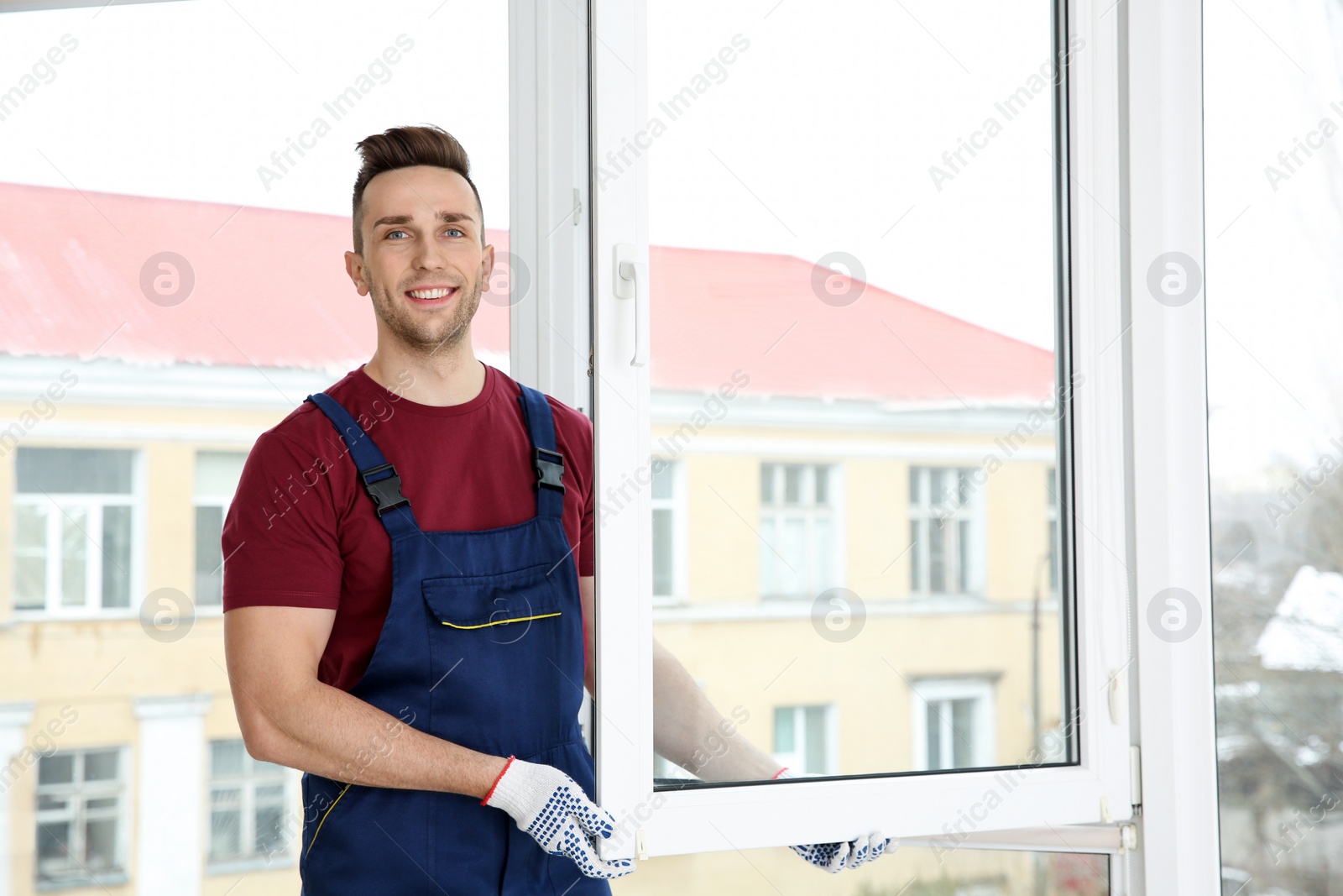 Photo of Construction worker installing plastic window in house