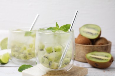 Photo of Refreshing drink with kiwi and mint on white table, closeup