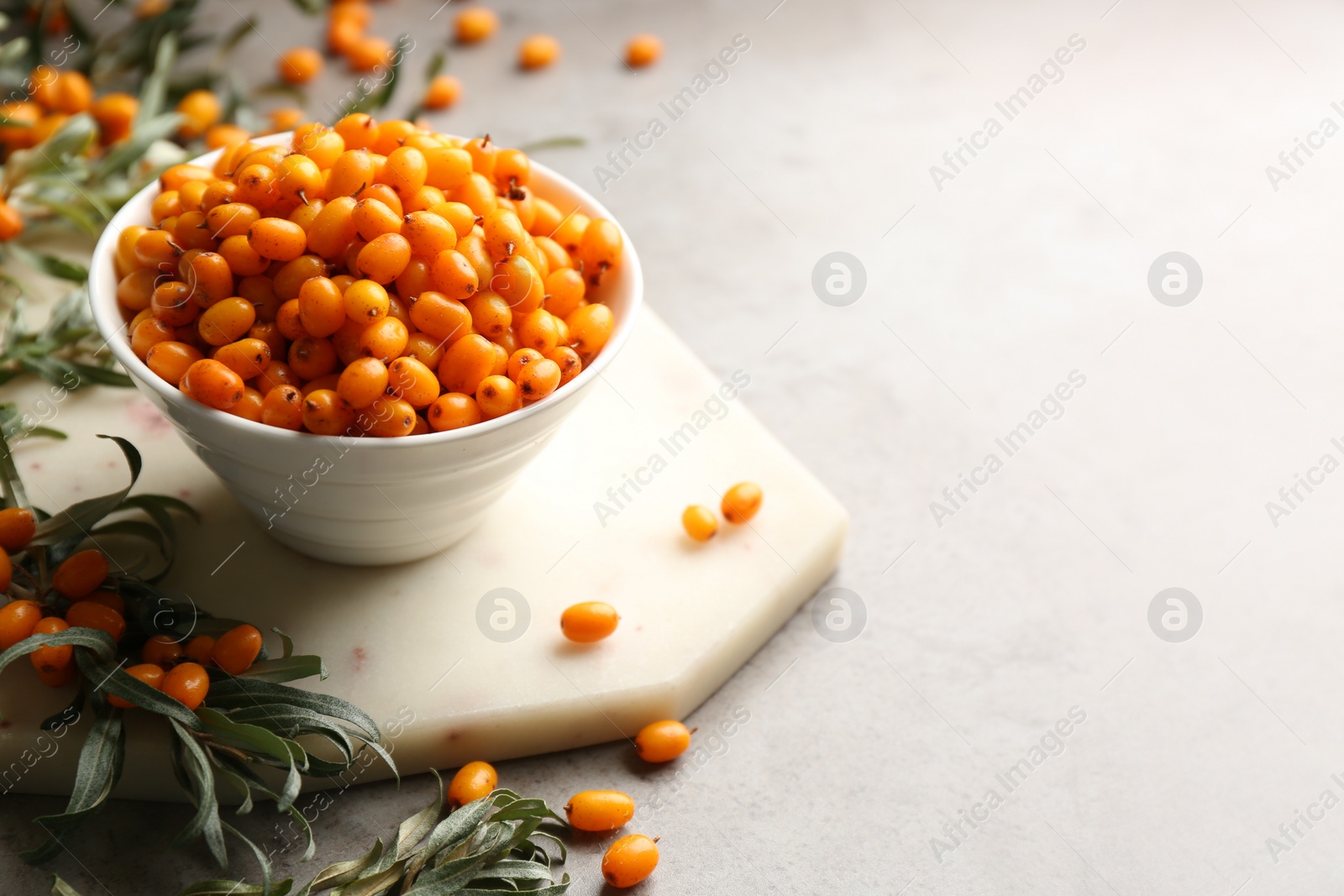 Photo of Fresh ripe sea buckthorn on grey table. Space for text