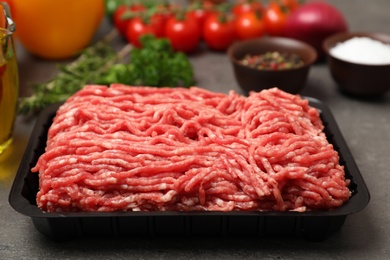 Photo of Plastic container with minced meat on kitchen table, closeup