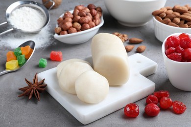Photo of Marzipan and other ingredients for homemade Stollen on grey table. Baking traditional German Christmas bread