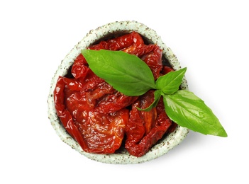 Photo of Bowl with sun dried tomatoes and green leaves on white background, top view