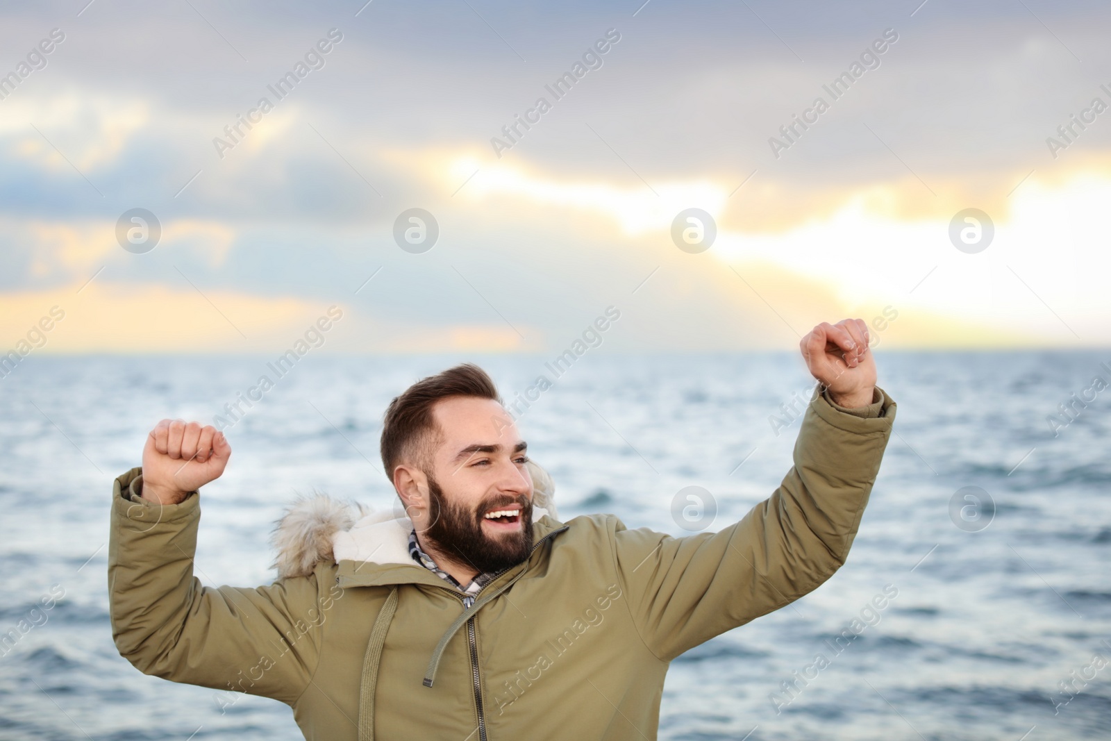 Photo of Stylish young man spending time near sea