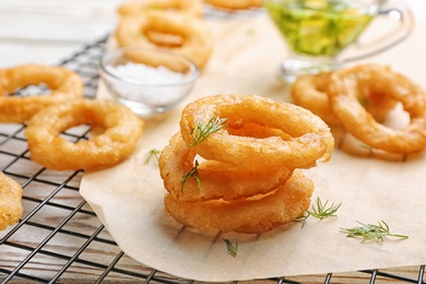 Fried onion rings on cooling rack, closeup