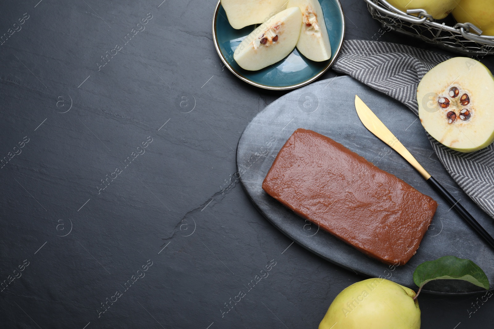 Photo of Flat lay composition with delicious quince paste on black table, space for text