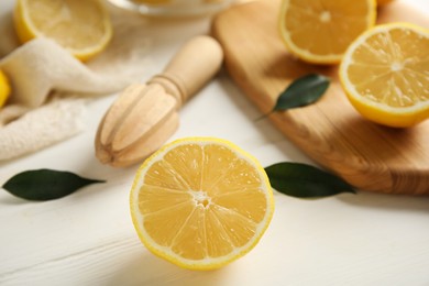 Photo of Wooden citrus reamer and fresh lemons on white table
