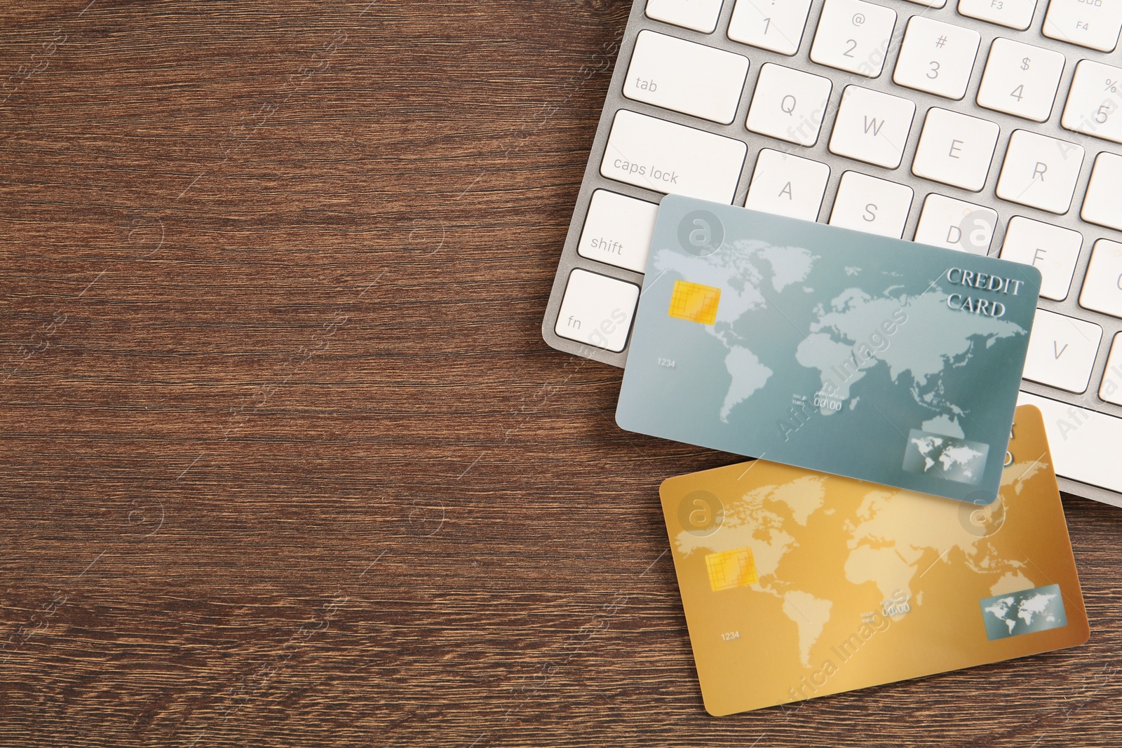 Photo of Online payment. Credit cards and keyboard on wooden table, flat lay with space for text