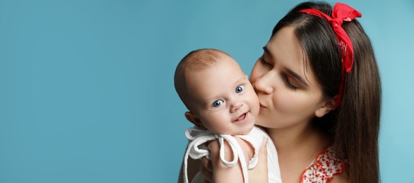 Image of Beautiful mother kissing her cute baby on light blue background, space for text. Banner design 