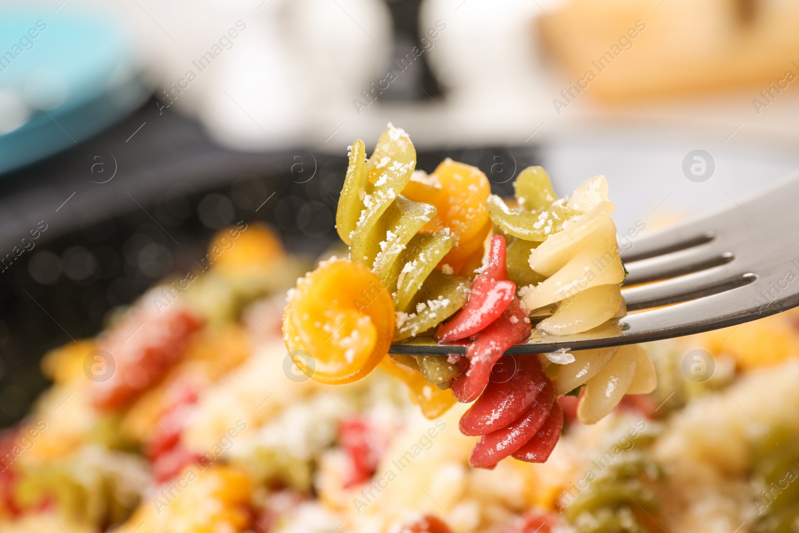 Photo of Colorful pasta with cheese on fork, closeup