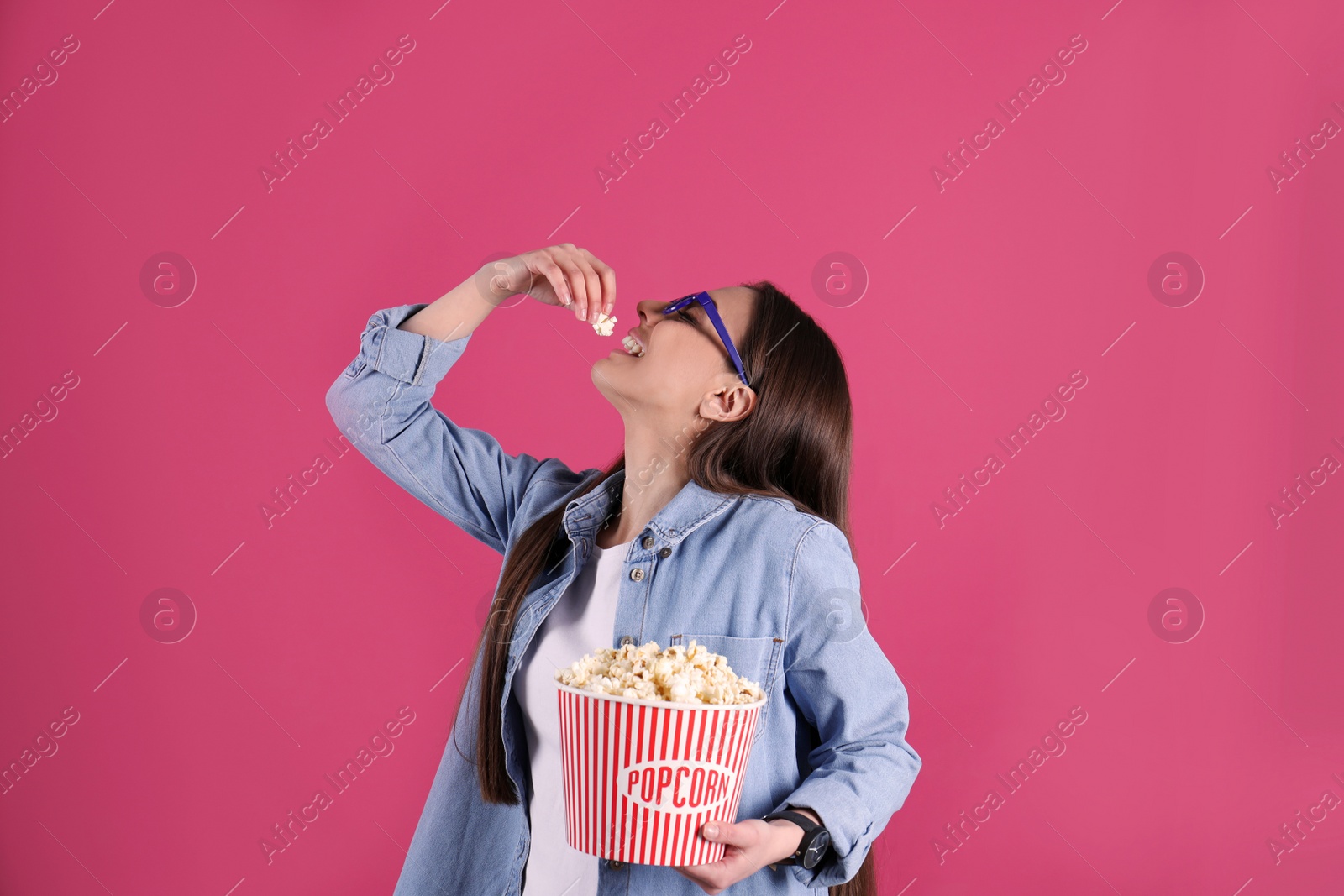 Photo of Young woman with 3D glasses eating tasty popcorn on color background