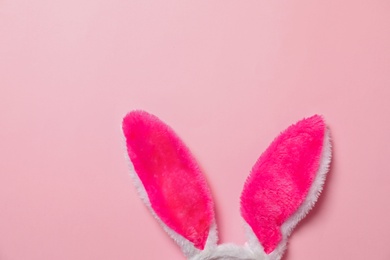 Photo of Funny Easter bunny ears on color background, top view