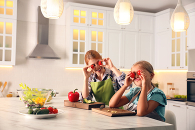 Photo of Mother and daughter cooking salad together in kitchen