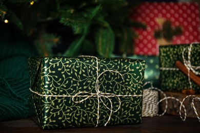 Photo of Composition with beautifully wrapped gift box on wooden table