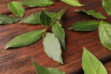 Aromatic fresh bay leaves on wooden table