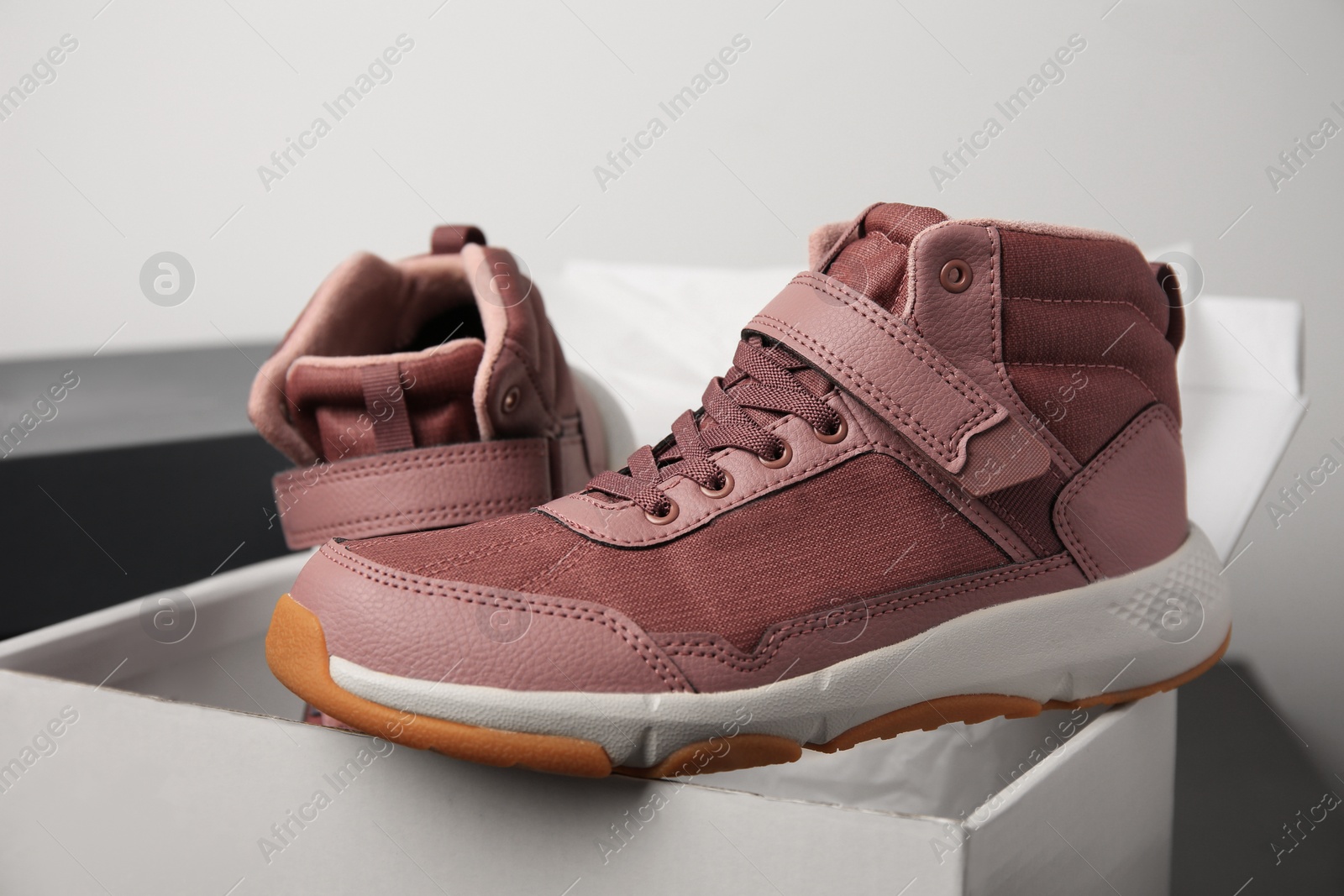 Photo of Pair of stylish kid's sneakers and box on table, closeup