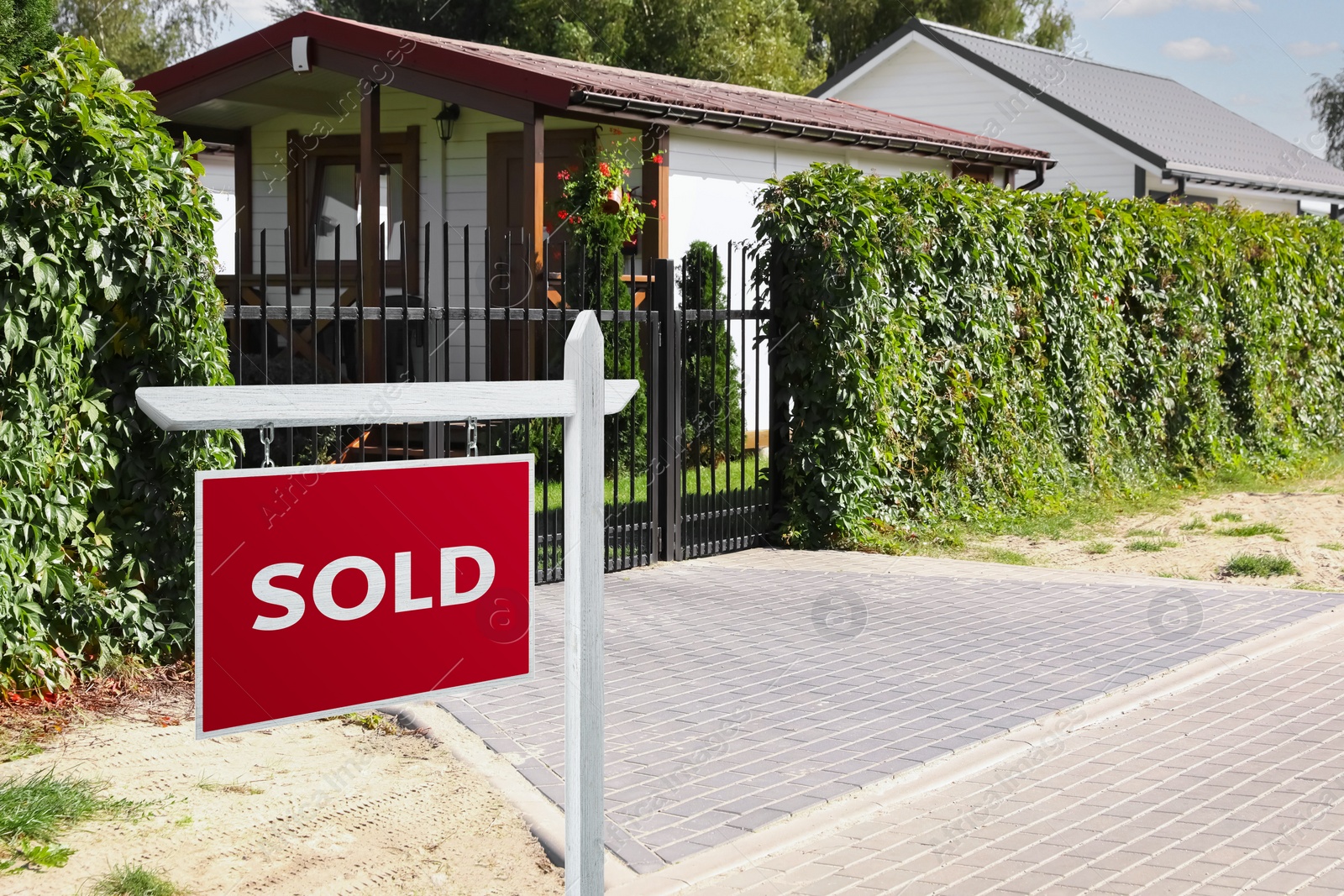 Image of Red Sold sign near beautiful house outdoors