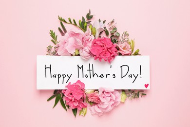 Image of Happy Mother's Day greeting card and beautiful flowers on pink background, flat lay