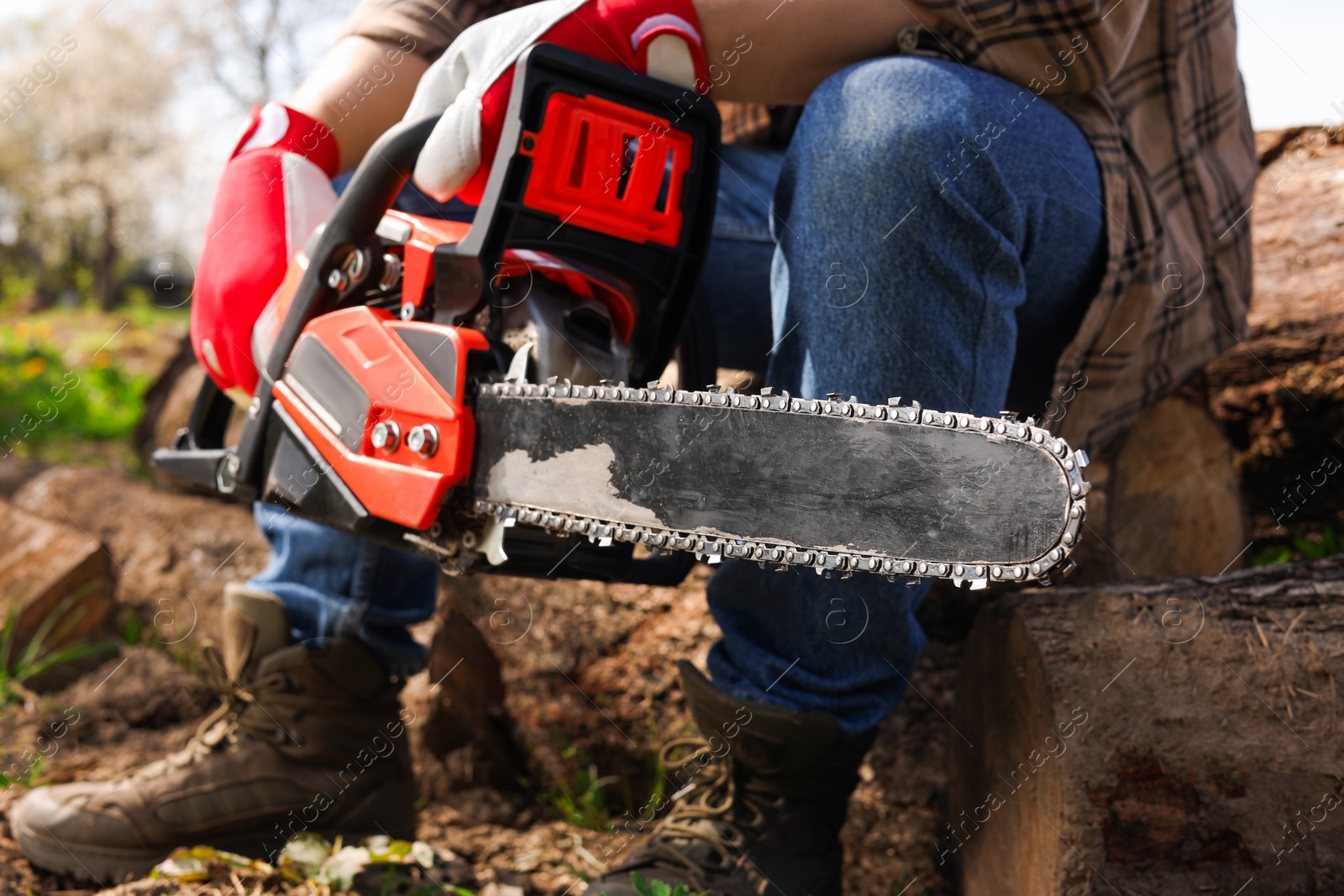 Photo of Man with modern electric saw outdoors, closeup