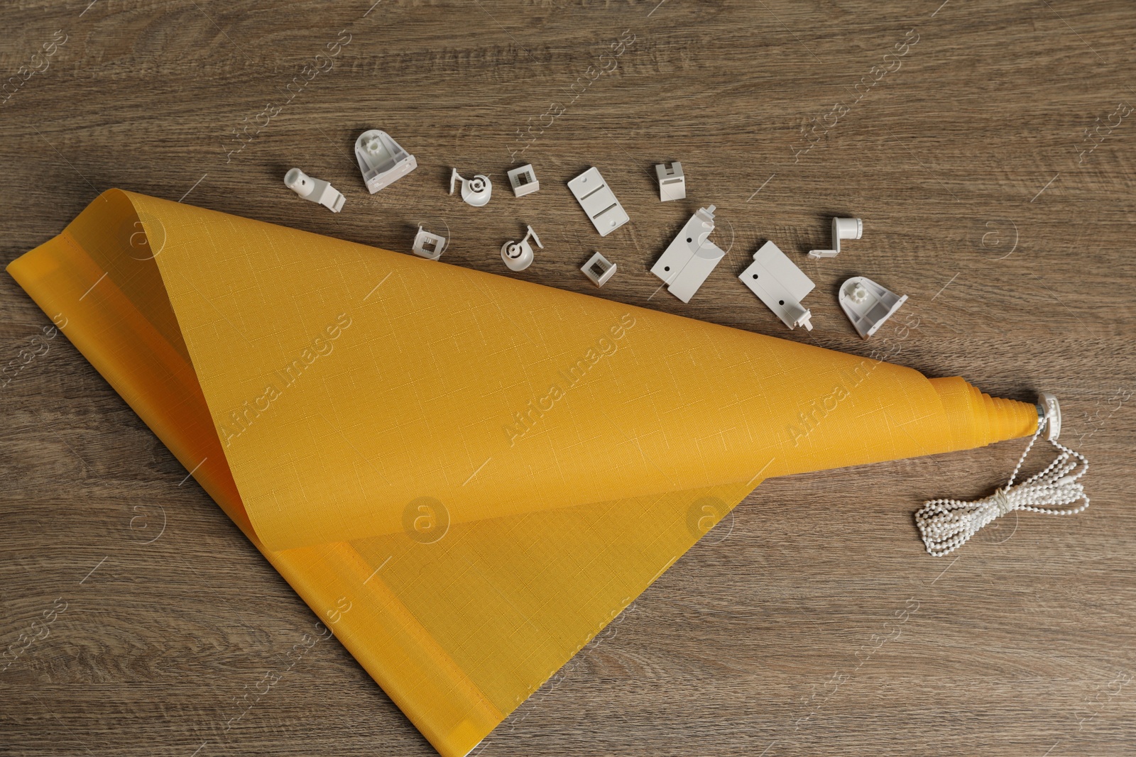 Photo of Stylish roller window blinds and details on wooden table, flat lay