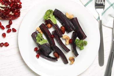 Photo of Tasty raw black carrot served on white wooden table, flat lay