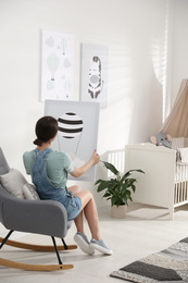 Photo of Decorator with picture sitting indoors. Children's room interior design