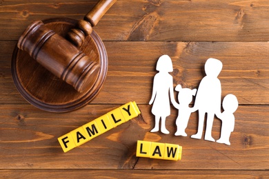 Flat lay composition with figure and gavel on wooden background. Family law concept