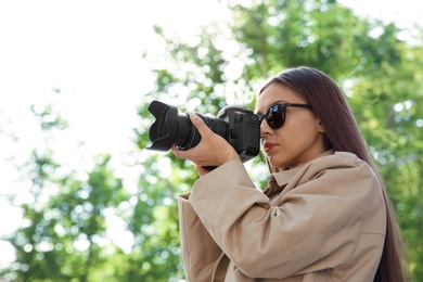 Private detective with camera spying in park