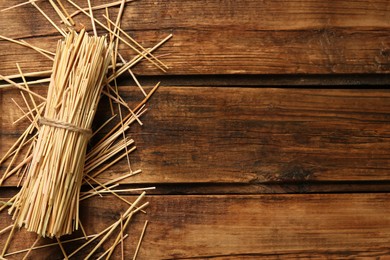 Sheaf of dried hay on wooden background, flat lay. Space for text