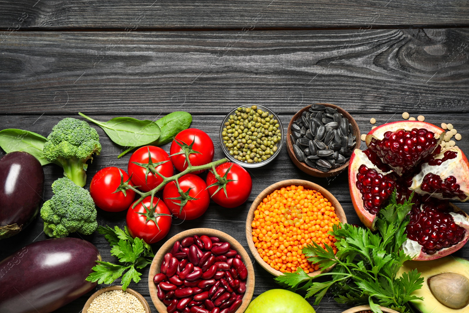 Photo of Different vegetables, seeds and fruits on black wooden table, flat lay with space for text. Healthy diet