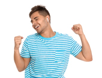 Photo of Happy young man listening to music through wireless earphones on white background