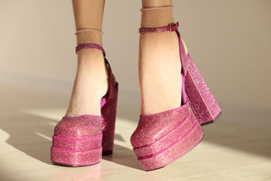 Photo of Woman wearing pink high heeled shoes with platform and square toes indoors, closeup