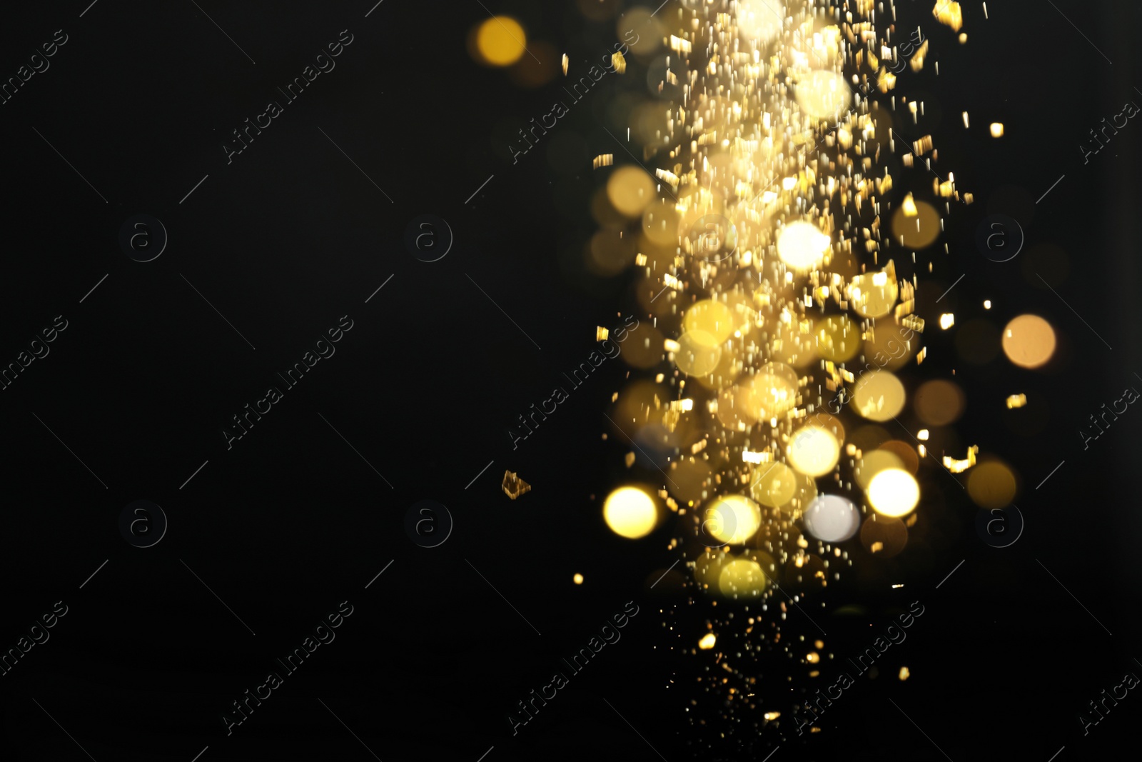 Photo of Blurred view of golden lights on black background. Bokeh effect