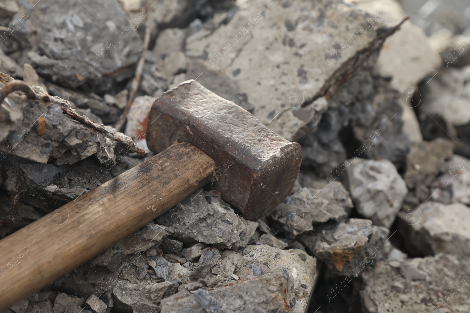 Photo of Sledgehammer on pile of broken stones outdoors, closeup