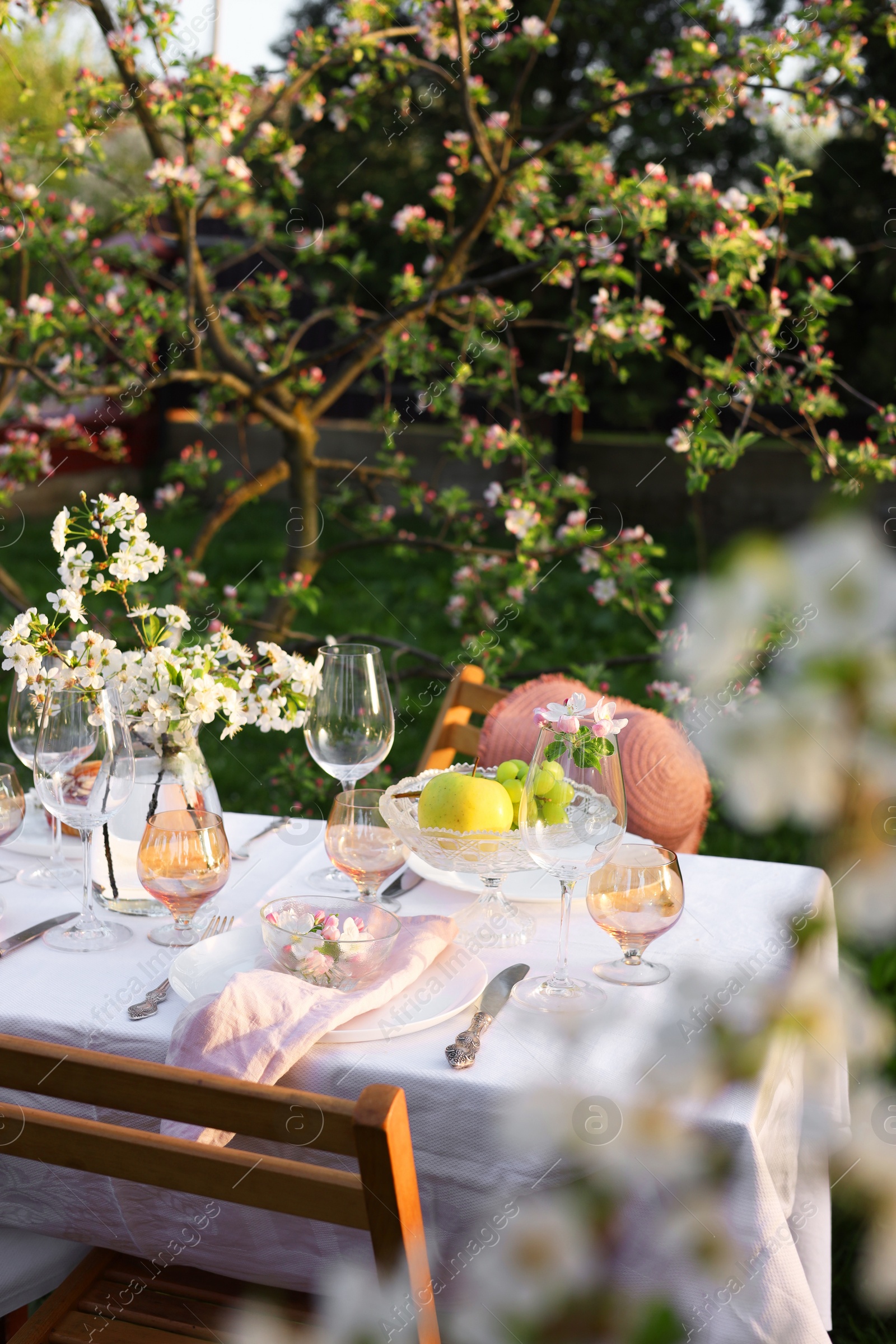 Photo of Stylish table setting with beautiful spring flowers in garden