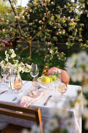 Stylish table setting with beautiful spring flowers in garden