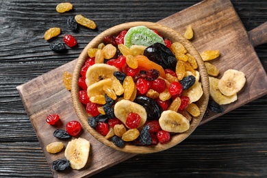 Photo of Bowl with different dried fruits on wooden background, top view. Healthy lifestyle