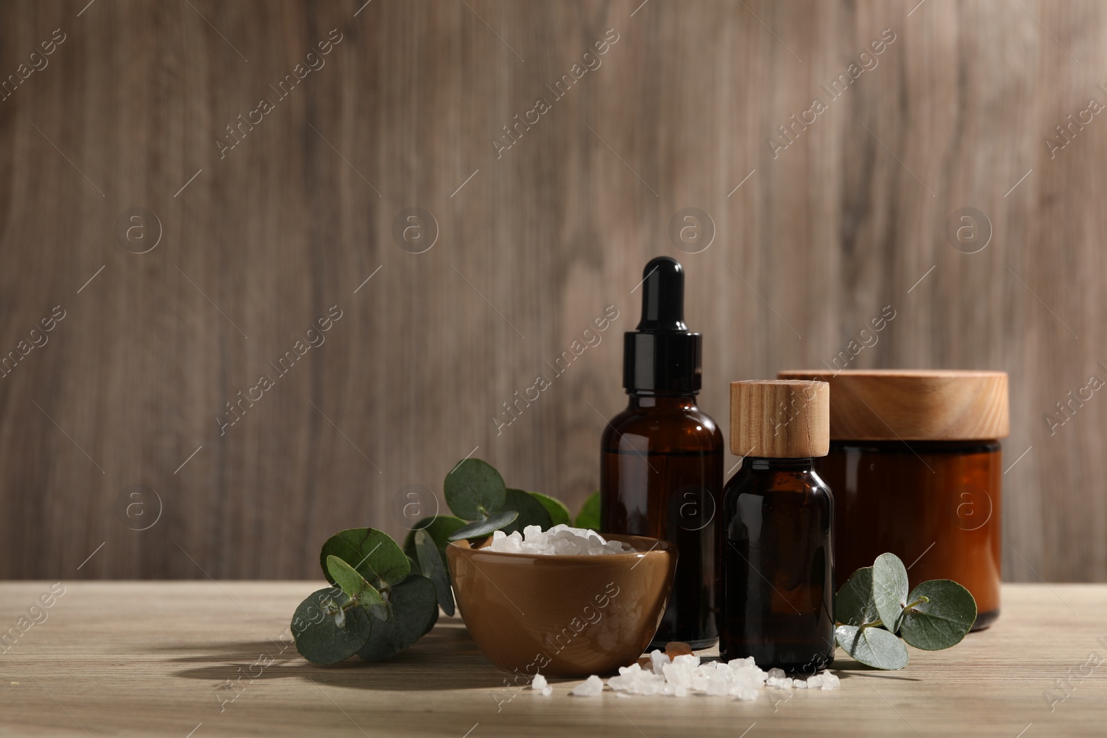 Photo of Composition with spa products and eucalyptus leaves on wooden table