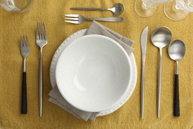 Stylish setting with cutlery, dishes and napkin on table, flat lay