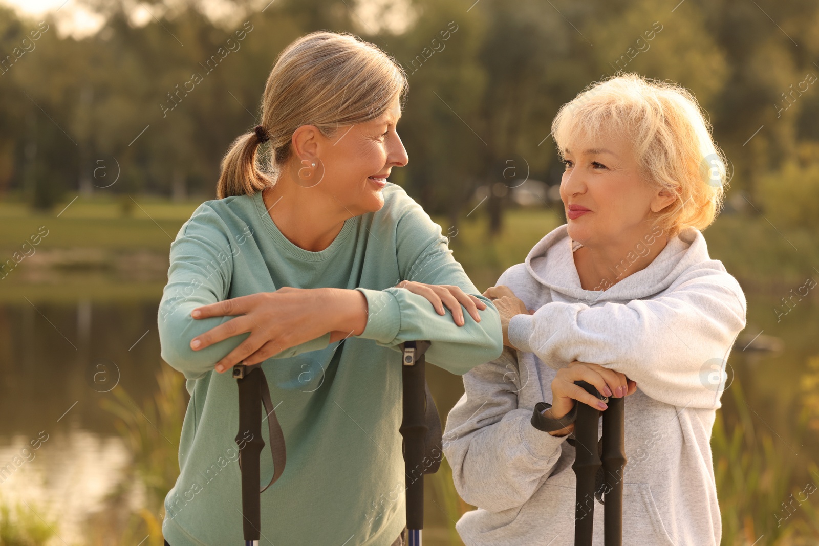 Photo of Two senior women with Nordic walking poles outdoors