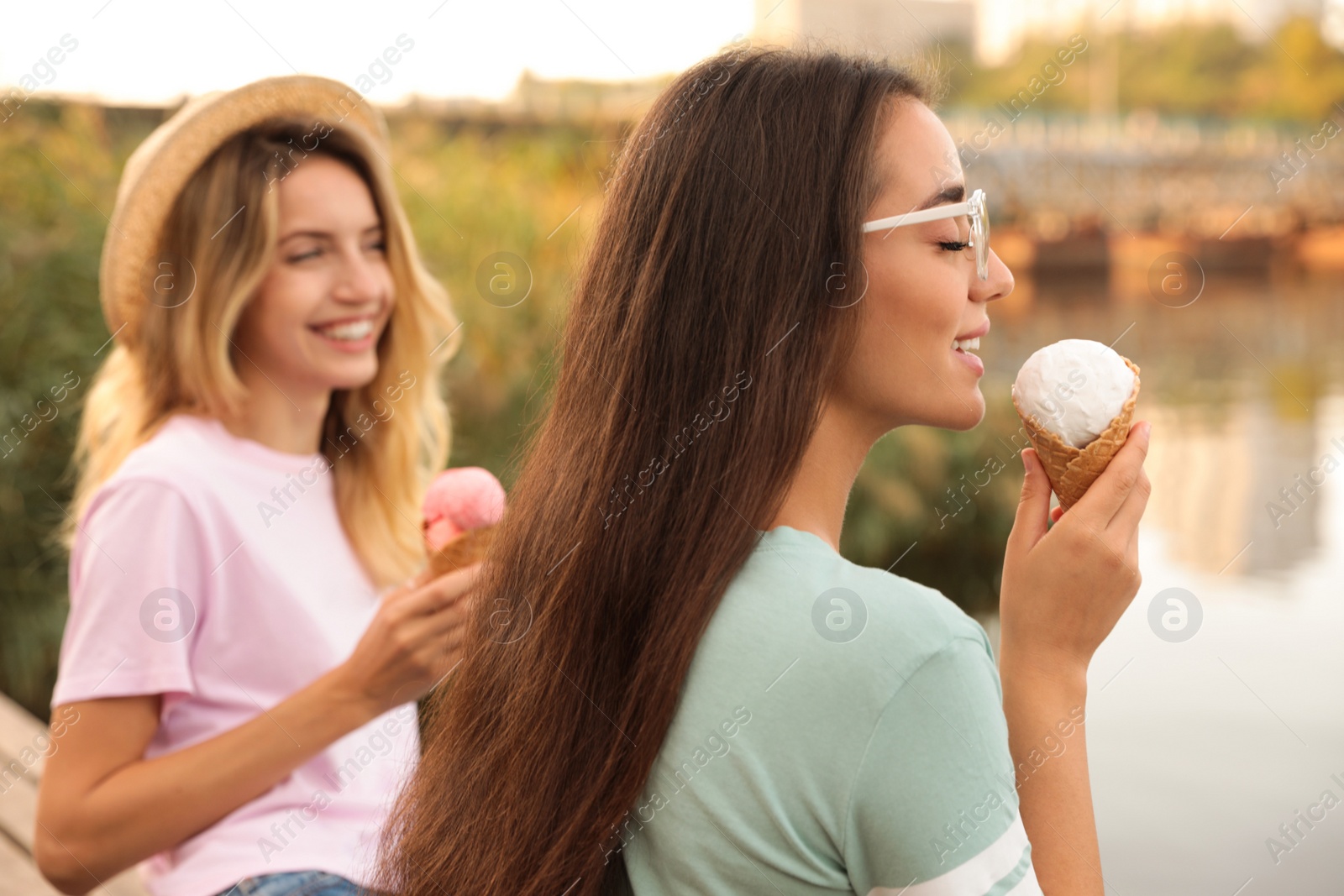 Photo of Young women with ice cream spending time together outdoors