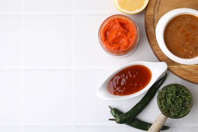 Photo of Different marinades and products on white tiled table, flat lay. Space for text