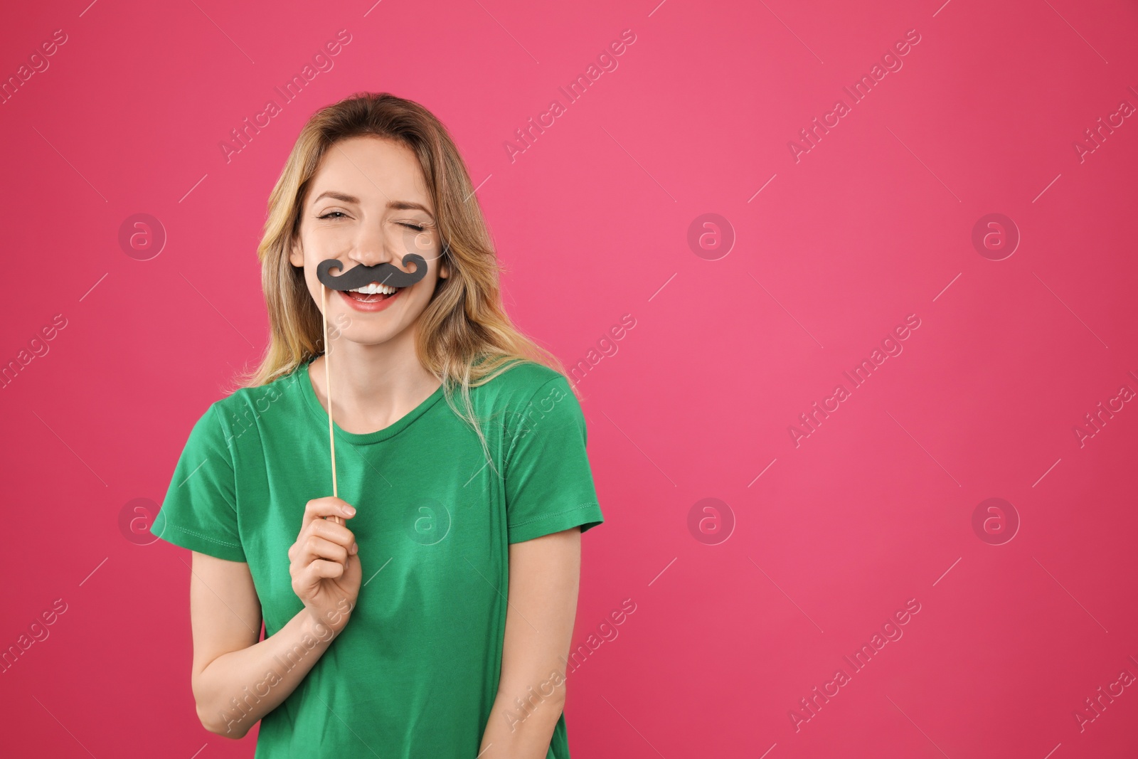 Photo of Funny woman with fake mustache on pink background, space for text